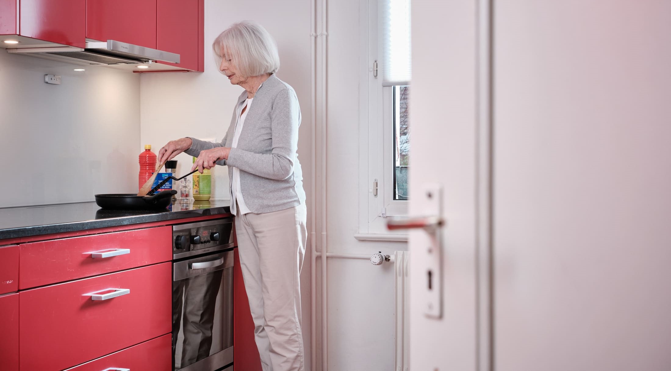 ältere Dame die an Herd steht und kocht